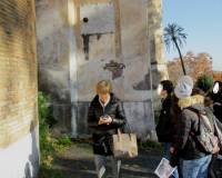 La prof.ssa Tiziana Di Crescenzo sotto la lapide che riporta la palla di cannone ritrovata tra i resti di alcune macerie della Chiesa di San Pietro Montorio